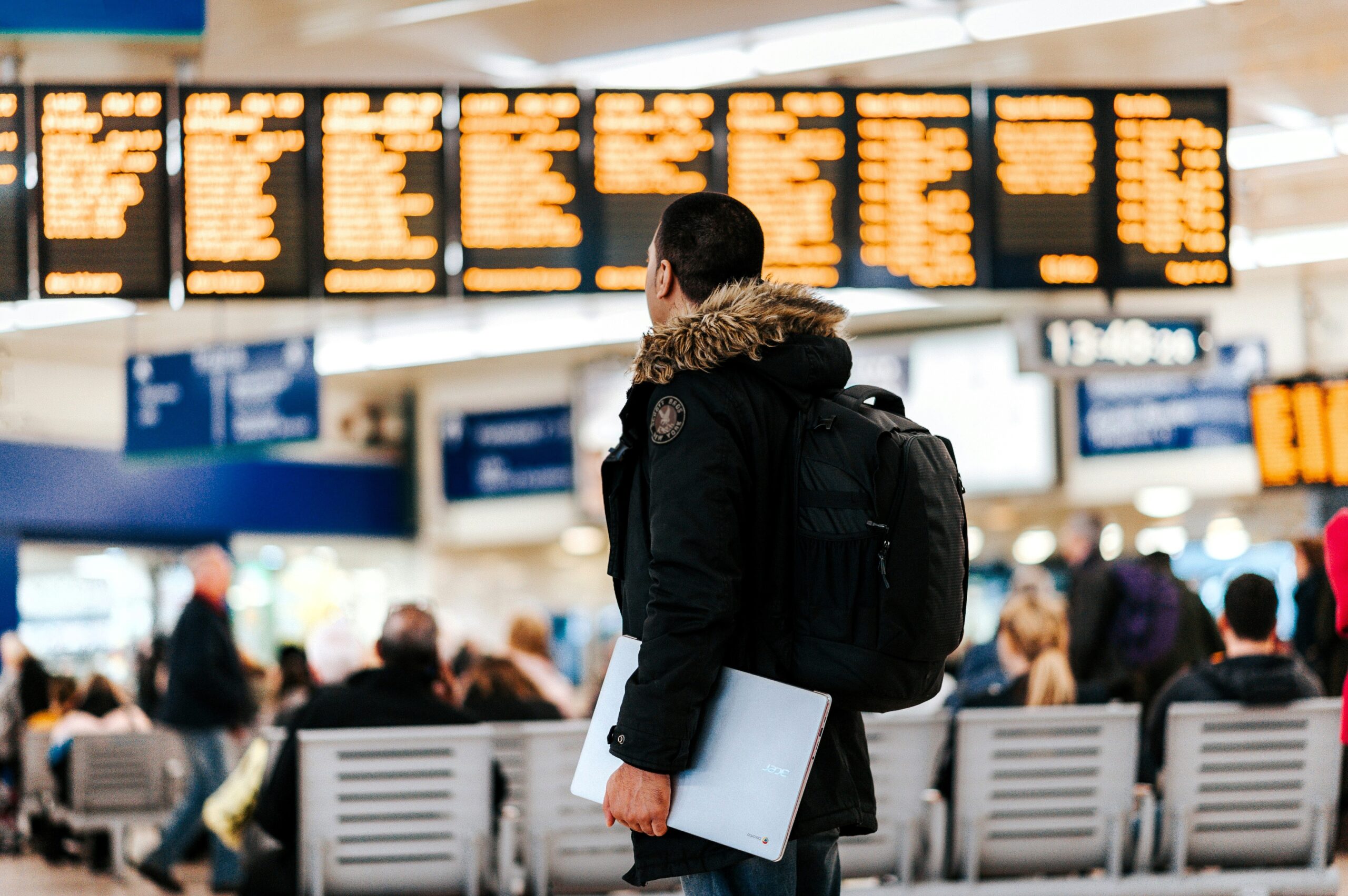 Traveller checking airport departure board for dummy return flight ticket booking